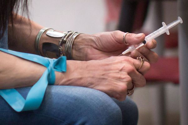 A woman injects hydromorphone at a clinic on Vancouver's Downtown Eastside in 2016